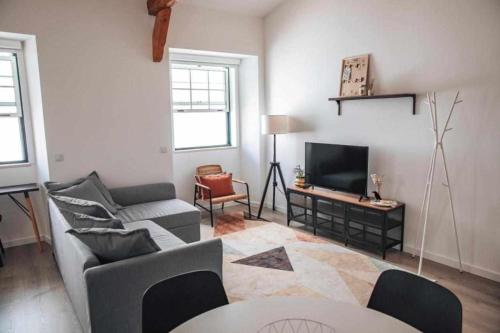 a living room with a couch and a tv at Casa d’Amélia in Leiria
