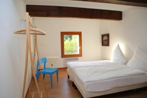 a bedroom with a white bed and a blue chair at Mas Companyo - Vallespir - Céret - Grand Mas in Céret