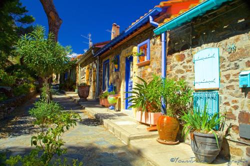 a street with plants in front of a building at The Originals City, Hôtel Les Dômes, Perpignan Sud Saleilles in Perpignan
