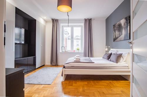 Un dormitorio con una cama grande y una ventana. en Apartments Floriańska 24 by MB Apartments, en Cracovia