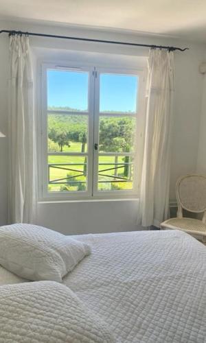 une chambre avec un lit et une grande fenêtre dans l'établissement Charmantes Haus im Golf Club Saint Tropez, à Saint-Tropez