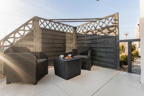 a pergola with two chairs and a table on a patio at Blue Wave Apartment by Renters in Ustronie Morskie