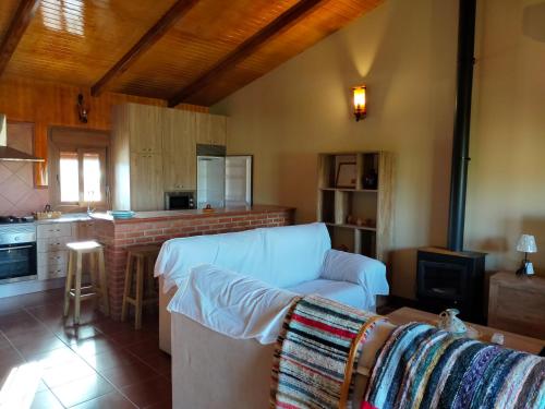 ein Wohnzimmer mit einem Sofa und einer Küche in der Unterkunft Complejo Rural La Paloma in Arroyo de la Luz