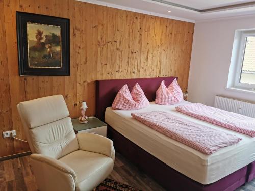 - une chambre avec un lit et une chaise dans l'établissement Ferienwohnung Kössler Christian, à Fügen