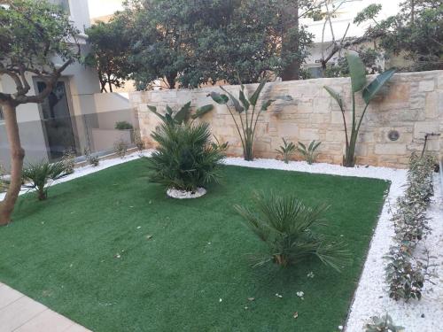 a small garden with green grass and plants at Nektar Beach Hotel in Stalos