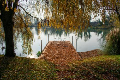 a dock on a lake with two chairs on it at Ca' del Sile in Morgano