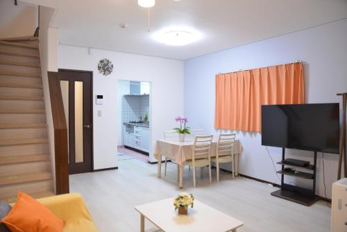a living room with a table and a television at K House in Tokyo