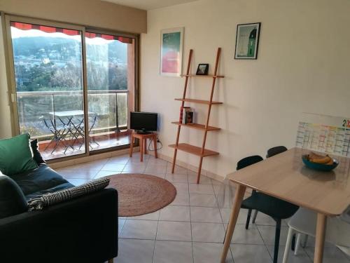 un salon avec un canapé et une table dans l'établissement Les jardins du Luxembourg, à Hyères