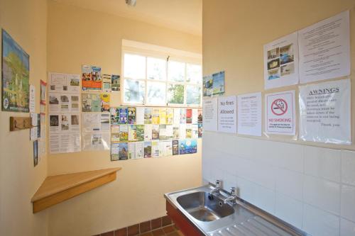 グレート・ドリフフィールドにあるMill Farm Shepherds Hutのバスルーム(シンク、壁にポスター付)