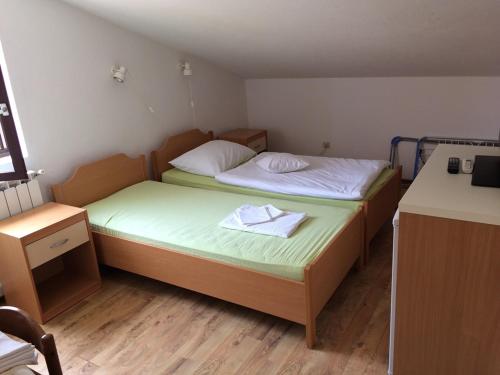 2 Betten in einem kleinen Zimmer mit einem Schreibtisch in der Unterkunft Vila Albatros in Rovinj