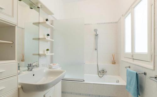 y baño blanco con lavabo y bañera. en Henry's House, en Santa Margherita Ligure