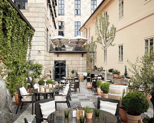 an outdoor patio with tables and chairs and plants at Four Seasons Hotel Prague in Prague