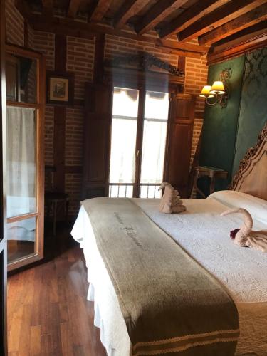 a bedroom with a large bed and a window at Hospederia Casa de Cisneros in Toledo
