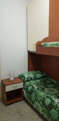 a bedroom with a bed and a nightstand next to a bunk bed at Vacanze in Sicilia in Siculiana
