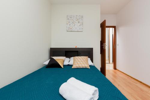 um quarto com uma grande cama azul com almofadas em Apartament Na Woli Sowińskiego by Renters em Varsóvia