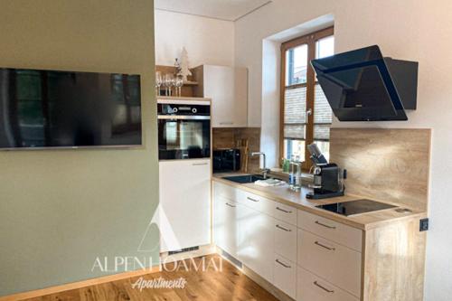 uma cozinha com um lavatório e um fogão forno superior em Alpenhoamat Apartments em Garmisch-Partenkirchen