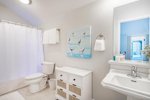 a white bathroom with a toilet and a sink at Evergreen at Semiahmoo in Blaine