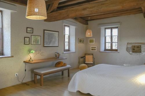 a bedroom with a bed and a desk and windows at Au Grand Fête, B&B à la campagne in Le Fête