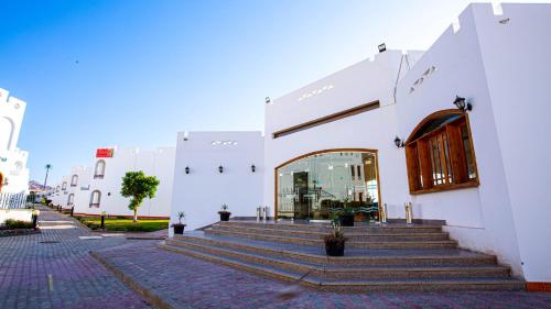 a white building with stairs and a door at Happy Life Village Dahab in Dahab