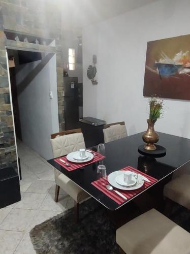 a dining room with a black table and chairs at Serra Negra - Melhor localização da cidade in Serra Negra