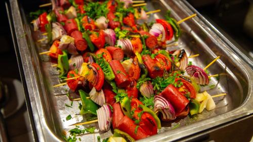 a tray of hot dogs and vegetables on skewers at Happy Life Village Dahab in Dahab