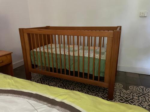 a wooden crib in a room with a bed at Casa Olivera- apartament al Passeig Font Vella in Sant Hilari Sacalm