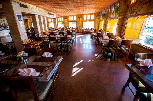 a dining room with tables and chairs in a restaurant at Happy Life Village Dahab in Dahab