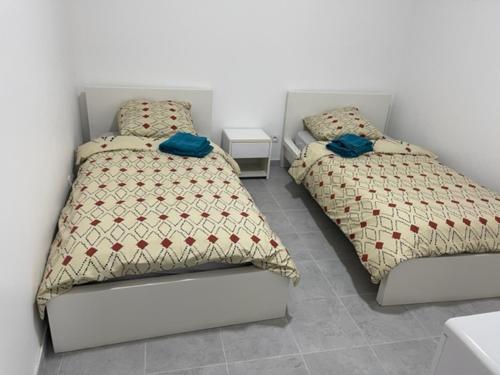 two beds sitting next to each other in a bedroom at RDC - Appartement F3 Villiers le Bel 95 Proche de Paris Roissy in Villiers-le-Bel