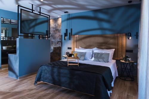 a bedroom with a bed with a blue wall at Nuovo Luxury Suite in Malia