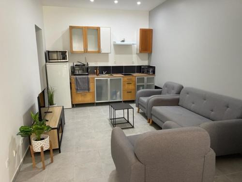 a living room with two couches and a kitchen at RDC - Appartement F3 Villiers le Bel 95 Proche de Paris Roissy in Villiers-le-Bel
