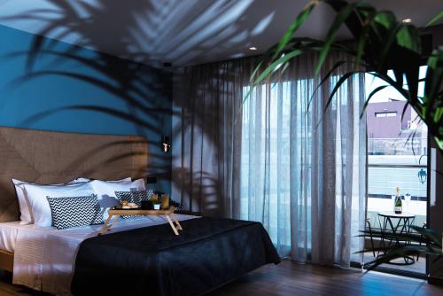 a bedroom with a bed and a large window at Nuovo Luxury Suite in Malia