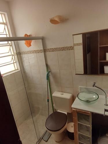 a bathroom with a shower and a toilet and a sink at Serra Negra - Melhor localização da cidade in Serra Negra