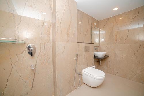 a bathroom with a toilet and a shower and a sink at Pearl Courtyard in Varanasi
