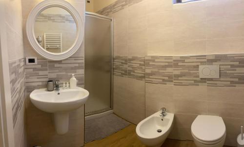 a bathroom with a sink and a toilet and a mirror at B&B Fior Di Toscana in Serravalle Pistoiese