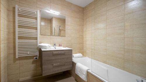 une salle de bain avec une baignoire et un lavabo et une baignoire dans l'établissement Les Freinets - Apt D201 - BO Immobilier- Multipass 2025 offert, à Châtel