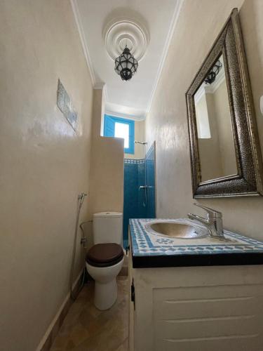 La salle de bains est pourvue de toilettes, d'un lavabo et d'un miroir. dans l'établissement Taghazout Ocean View, à Taghazout