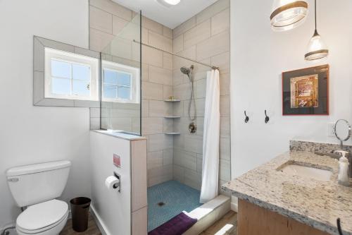 a bathroom with a shower and a toilet and a sink at Hotel Folly with Marsh and Sunset Views in Folly Beach