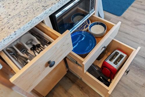 an open kitchen cabinet with plates and dishes in it at Hotel Folly with Marsh and Sunset Views in Folly Beach
