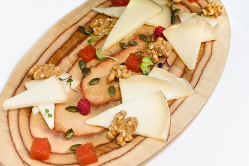 a plate of food with cheese and fruit and nuts at Torre del Marqués Hotel Spa & Winery - Small Luxury Hotels in Monroyo