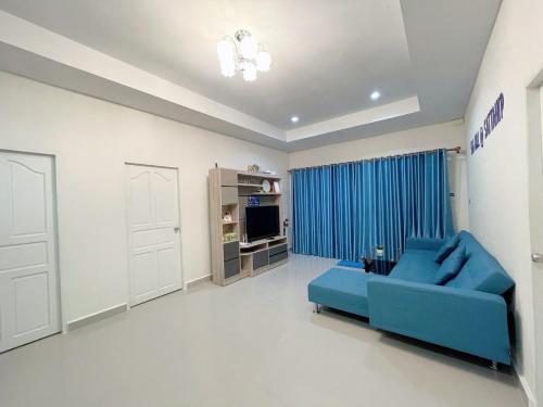 a living room with a blue couch and a television at Sea Hill Sattahip in Sattahip