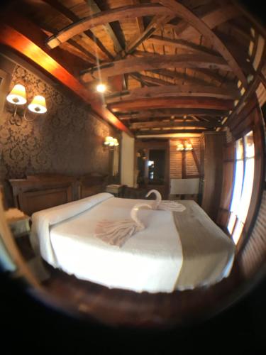 a bedroom with a large bed in a room with wooden ceilings at Hospederia Casa de Cisneros in Toledo