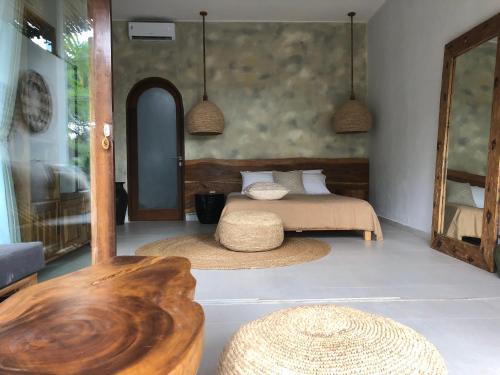 a bedroom with a bed and a table and a mirror at Nagara Boutique Hotel in Jimbaran