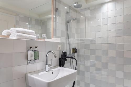 a white bathroom with a sink and a shower at Mimosa House in Westerland (Sylt)