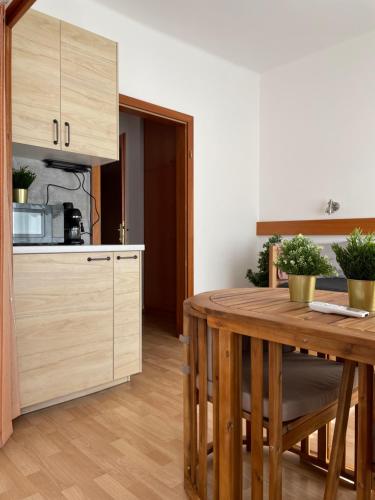 a kitchen with a wooden table and a counter top at Hello Balcsi Apartmanház in Tihany