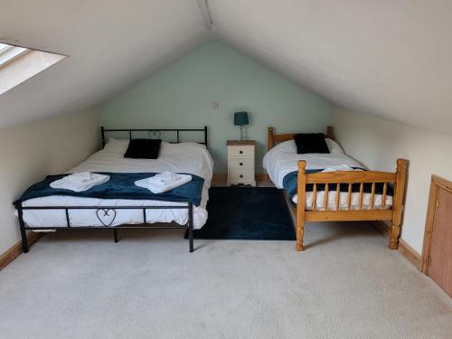 a bedroom with two beds in a attic at The Annexe in Ulverston