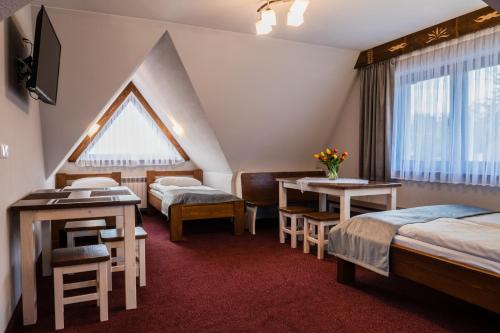 um quarto de hotel com duas camas e uma janela em Willa Słoneczna - Pokoje i apartamenty - 10 minut do term na piechotę em Bukowina Tatrzańska