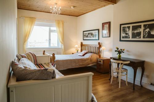 a bedroom with a bed and a table and a desk at Innish Beg Cottages in Blaney