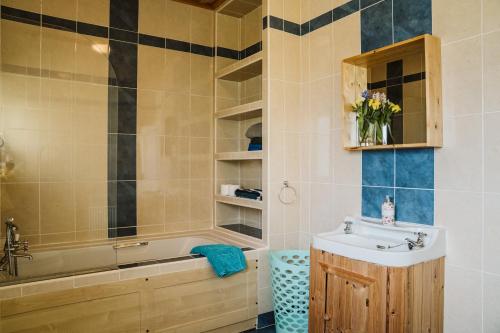 a bathroom with a sink and a bath tub and a sink at Innish Beg Cottages in Blaney