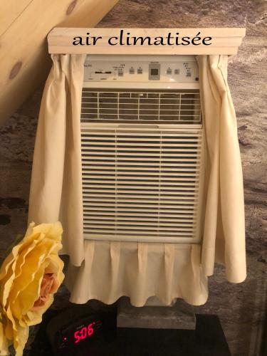 an air conditioner with a curtain on top of it at Appartement champêtre in Saguenay
