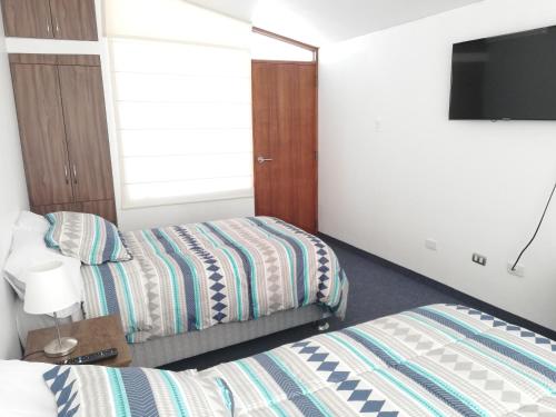 Habitación de hotel con 2 camas y TV de pantalla plana. en Andina Lodge, en Arequipa